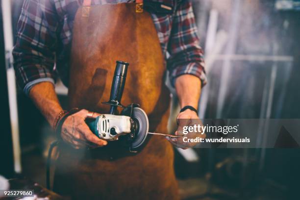 smid werken met elektrisch gereedschap in werkplaats - metal sanding stockfoto's en -beelden