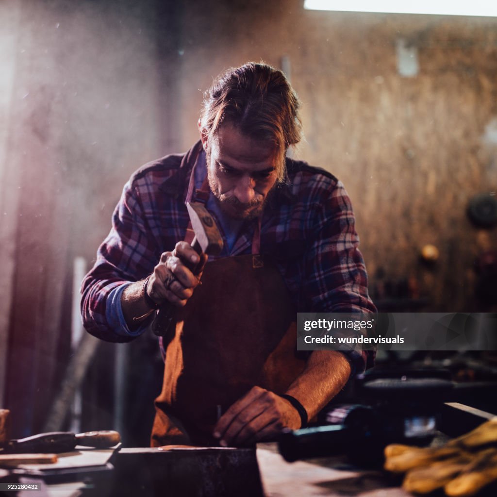 Carpenter working with hammer and nails in workshop