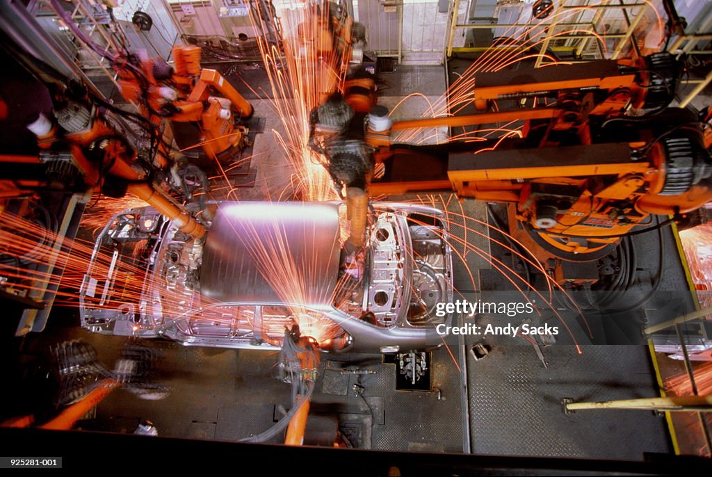 Car assembly line, robotic welding on car body, overhead view