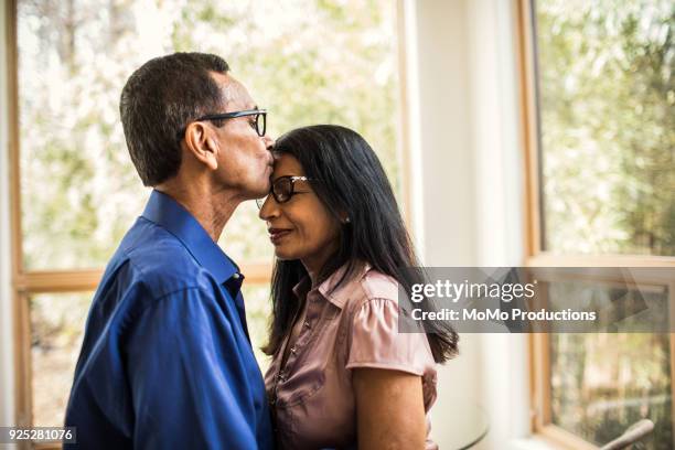 senior man kissing wife at home - indian couple at home imagens e fotografias de stock