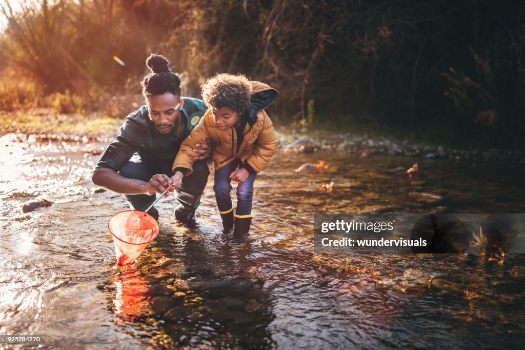 Padre e hijo pescando con red en el río de pesca