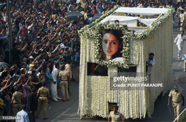 Indian fans watch as the funeral cortege of the late Bollywood actress Sridevi Kapoor passes through Mumbai ahead of her cremation on February 28,...