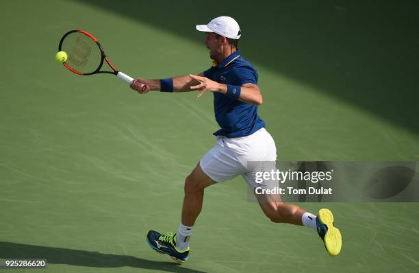Roberto Bautista Agut of Spain plays a forehand during his match against Pierre-Hugues Herbert of France on day three of the ATP Dubai Duty Free...