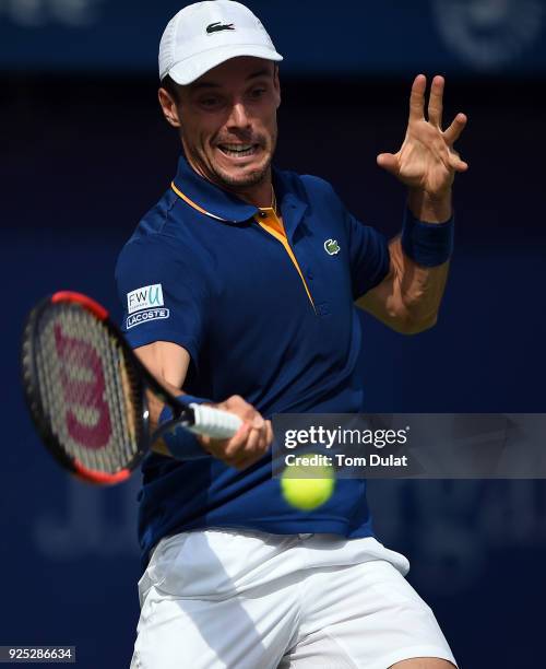 Roberto Bautista Agut of Spain plays a forehand during his match against Pierre-Hugues Herbert of France on day three of the ATP Dubai Duty Free...