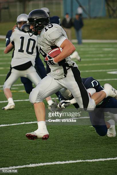 football running back carries ball for big gain - cleat stock pictures, royalty-free photos & images