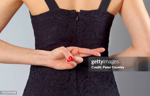 fingers crossed behind back for good luck - blessing fotografías e imágenes de stock