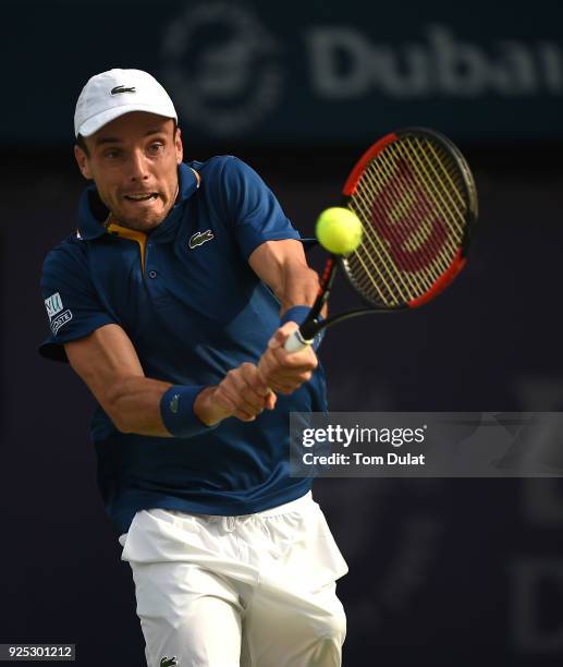 Roberto Bautista Agut of Spain plays a forehand during his match against Pierre-Hugues Herbert of France on day three of the ATP Dubai Duty Free...