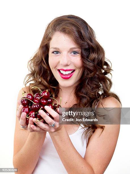 girl holding handful of fresh cherries - monrovia california stockfoto's en -beelden