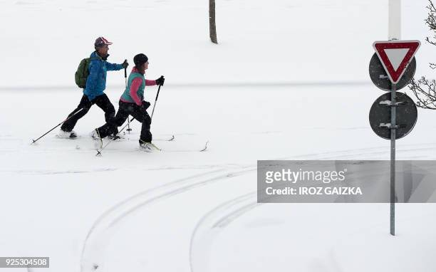 Couple ski on a snow covered street of Biarritz, southwestern France, on February 28 after heavy snow fall. Europe remained on February 28 gripped by...