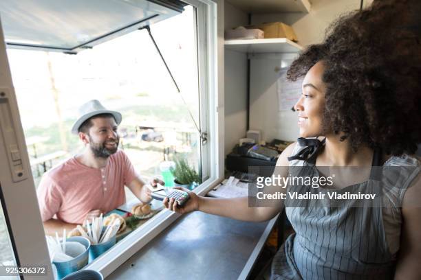 client using credit card for payment in food van - food truck payments stock pictures, royalty-free photos & images