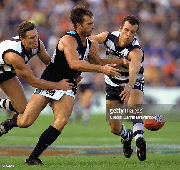 Darryl Wakelin from Port Adelaide battles Ben Graham and Mitchell White both from Geelong during the round 5 AFL match between the Geelong Cats and...