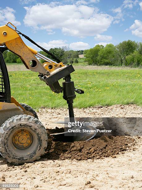 skid steer with auger drilling hole for tree - trapano foto e immagini stock
