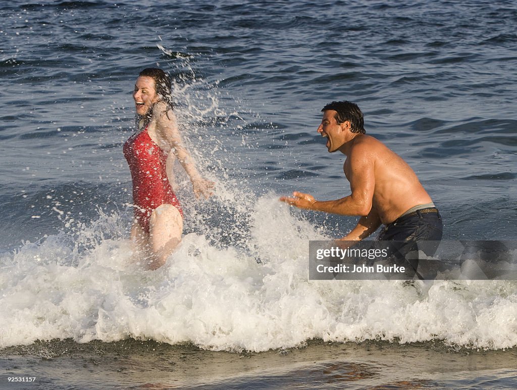 Man splashing woman in the surf