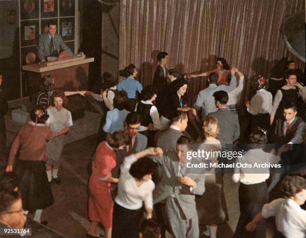 Television host Dick Clark presides over the set of his show 'American Bandstand' as teenagers dance to top 40 popular music circa 1957 in...