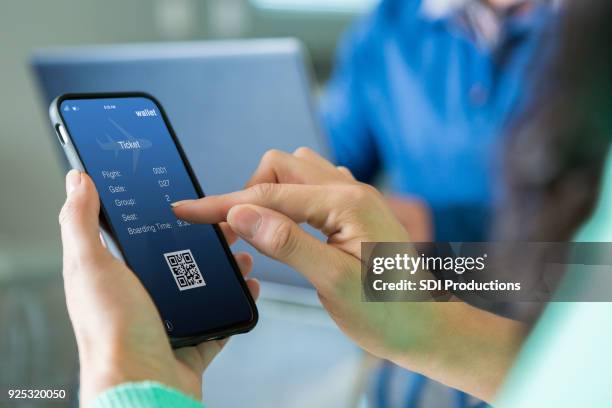 woman uses smart phone to book travel reservation - airplane ticket stock pictures, royalty-free photos & images