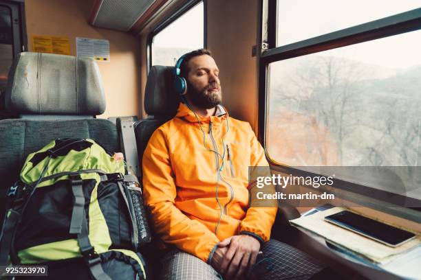 ontspannen man in de trein - luisteren stockfoto's en -beelden