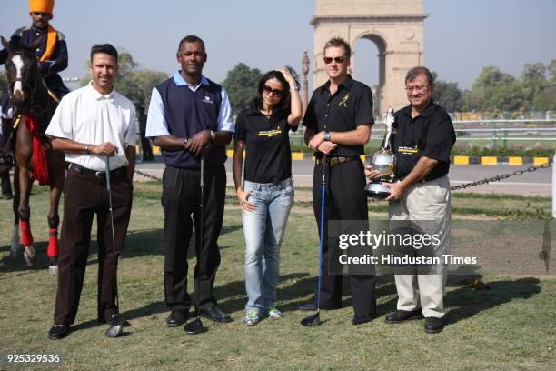 British golfer Ian Poulter , Vijay Singh of Fiji and India's Jeev Milkha Singh pose for a photograph during a welcoming ceremony ahead of the Johnnie...