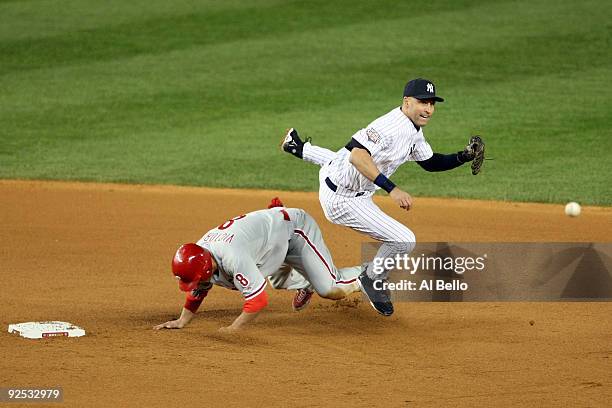 Derek Jeter of the New York Yankees turns a double play against Shane Victorino of the Philadelphia Phillies in Game Two of the 2009 MLB World Series...