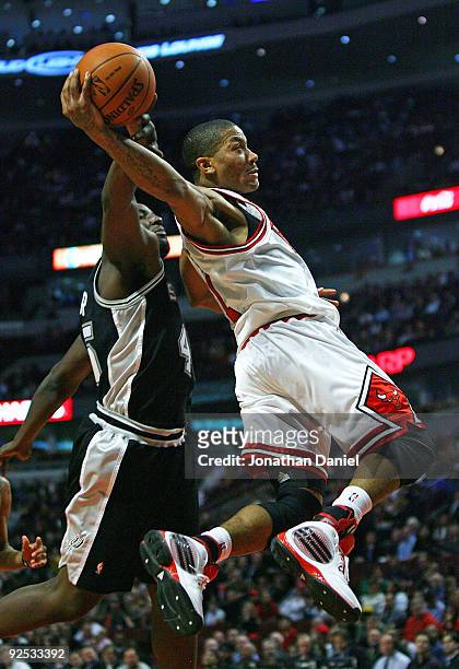 DeJuan Blair of the San Antonio Spurs fouls Derrick Rose of the Chicago Bulls as he goes up for the shot at the United Center on October 29, 2009 in...