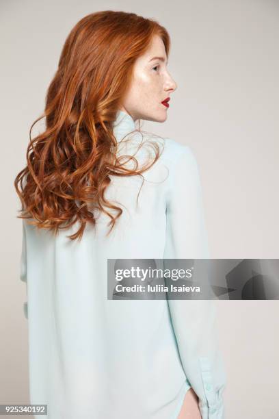 redhead woman in blue blouse - atelier mode stock-fotos und bilder