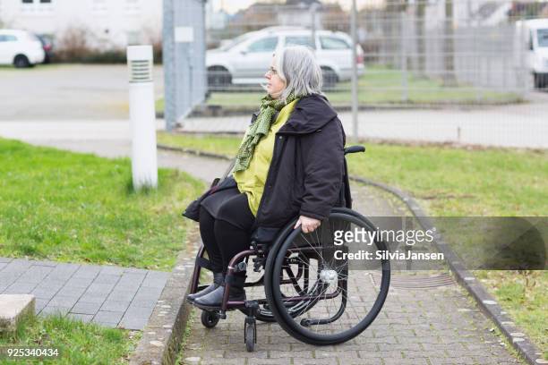 wheelchair driver facing a barrier - social exclusion stock pictures, royalty-free photos & images