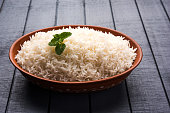 Cooked plain white basmati rice in terracotta bowl over plain or wooden background
