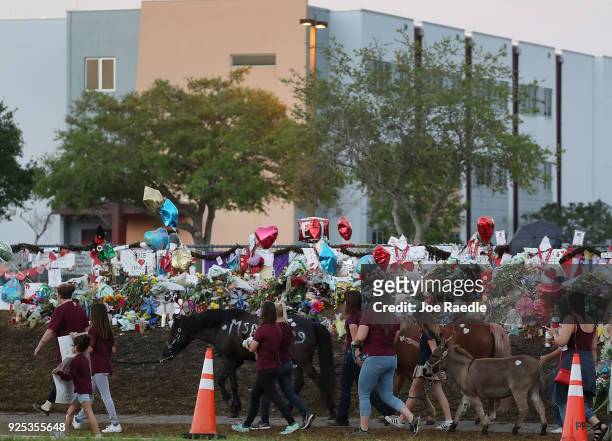 People arrive to offer support at Marjory Stoneman Douglas High School as student arrive to attend classes for the first time since the shooting that...