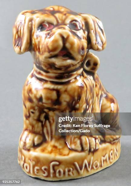 Brown-washed, porcelain figurine, depicting a dog, looking sideways, and a caption at the base reading "Votes for Women, " produced for both the...
