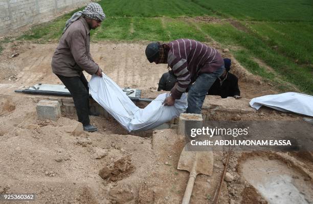 Graphic content / Syrian civil defence volunteers prepare to bury the body of a victim who died in a building collapse following reported regime...