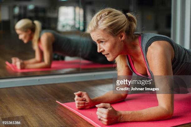 woman exercising on mat - krafttraining stock-fotos und bilder