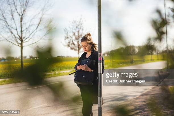 pregnant woman standing at bus station - waiting bus stock pictures, royalty-free photos & images