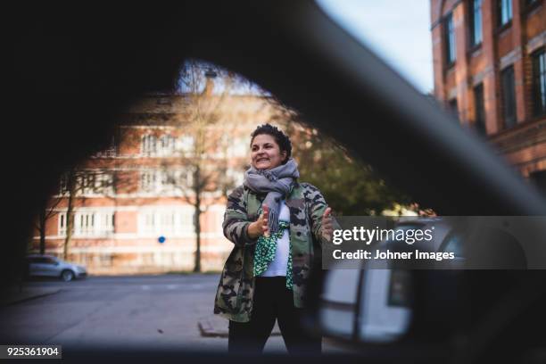 woman standing in street - parking stock pictures, royalty-free photos & images
