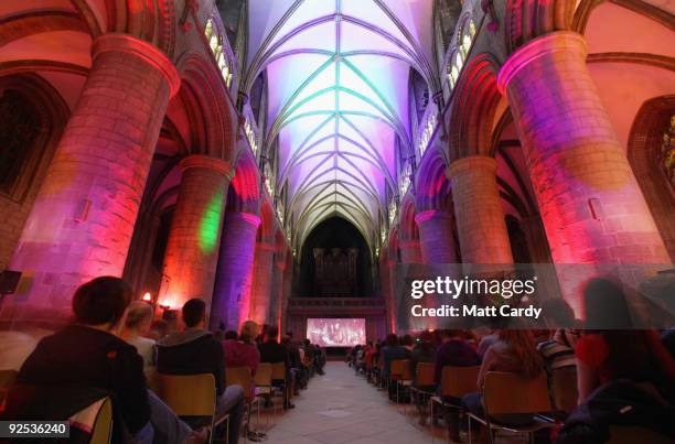 People sit between the 11th century Norman columns in the Romanesque nave as a projectionist shows the film Harry Potter and the Half-Blood Prince on...