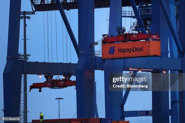 Crane transports a Hapag-Lloyd AG shipping container at the HHLA Container Terminal Burchardkai in the Port of Hamburg in Hamburg, Germany, on...