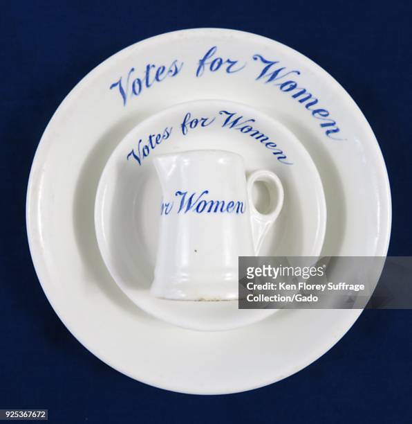 Set of ceramic dishes, including two bowls, or a plate and bowl, and a creamer-style cup or jug, each white with blue text reading "Votes for Women,...