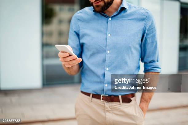 man using cell phone in front of office - helsingborg if stock pictures, royalty-free photos & images