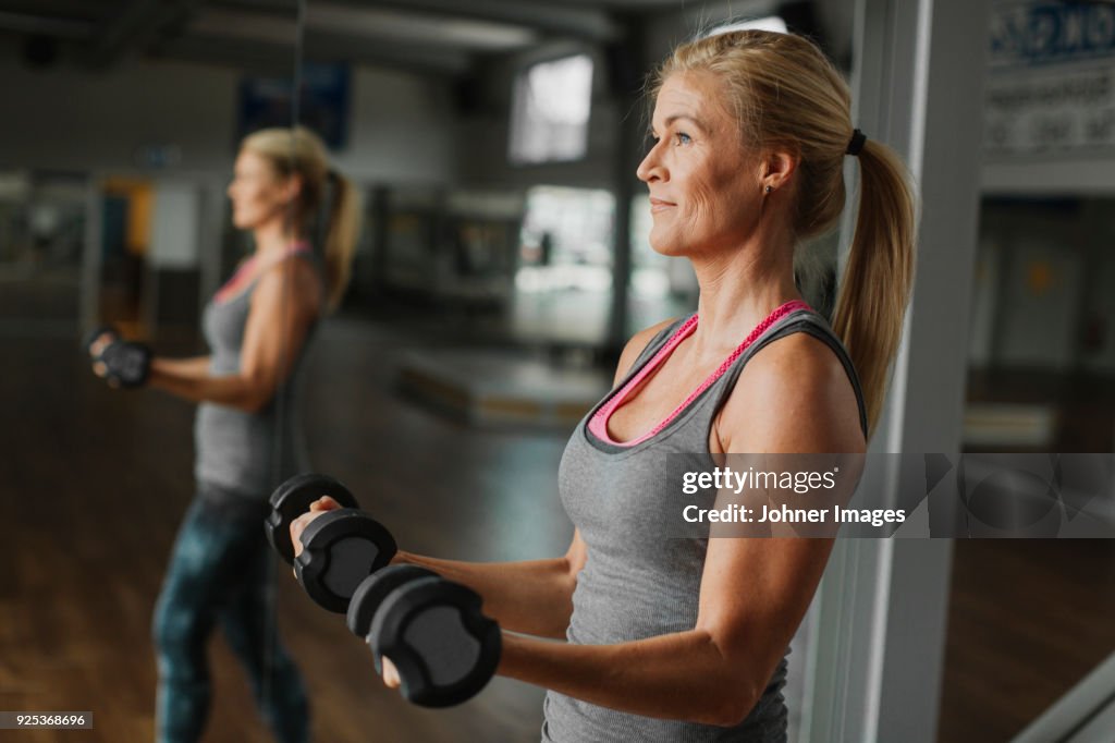 Woman exercising with dumbbells in gym