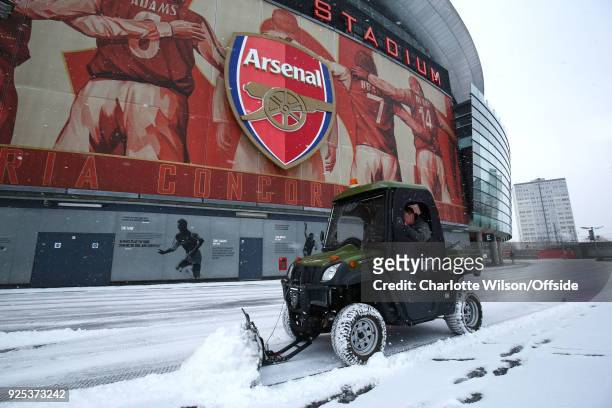 Groundsman drives a small snow plough around The Emirates to clear the concourse of snow at Emirates Stadium on February 28, 2018 in London, England.