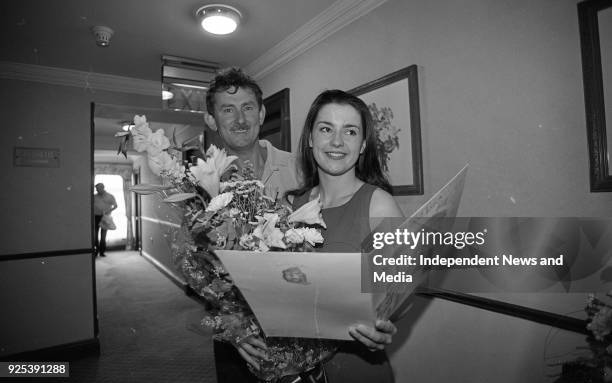 Contestant in the Rose of Tralee International Festival, holding a bouquet and a large Good Luck card, Tralee, County Kerry, Ireland, circa August...