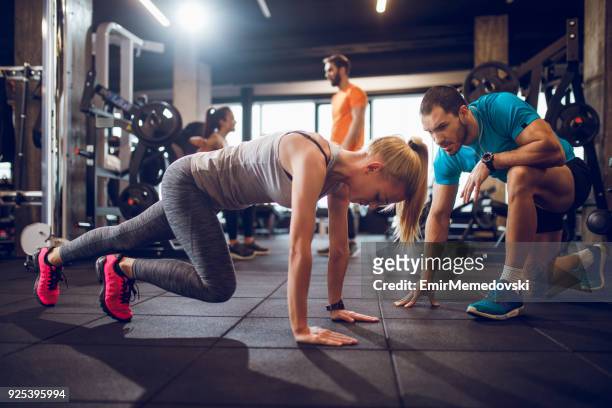jonge vrouw doet stretching oefening - coach stockfoto's en -beelden