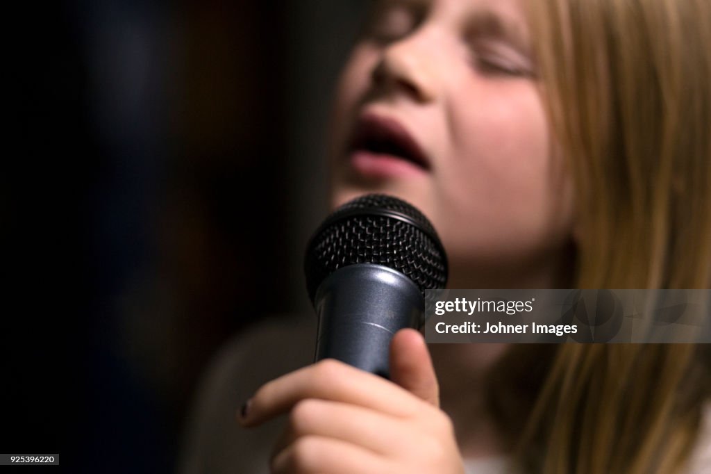 Girl holding microphone and singing
