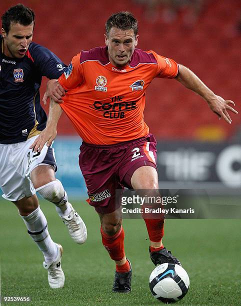 Andrew Packer of the Roar attempts to break away from the defence of Labinot Haliti of the Jets during the round 13 A-League match between the...