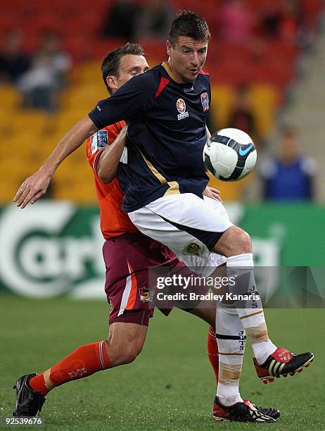 Andrew Packer of the Roar challenges Michael Bridges of the Jets during the round 13 A-League match between the Brisbane Roar and the Newcastle Jets...