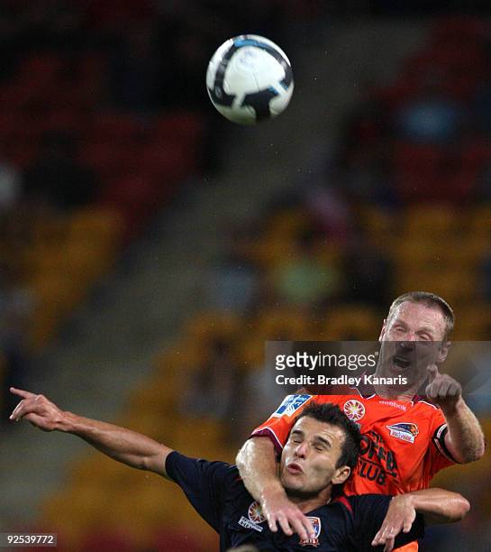 Craig Moore of the Roar and Labinot Haliti of the Jets compete for the ball during the round 13 A-League match between the Brisbane Roar and the...