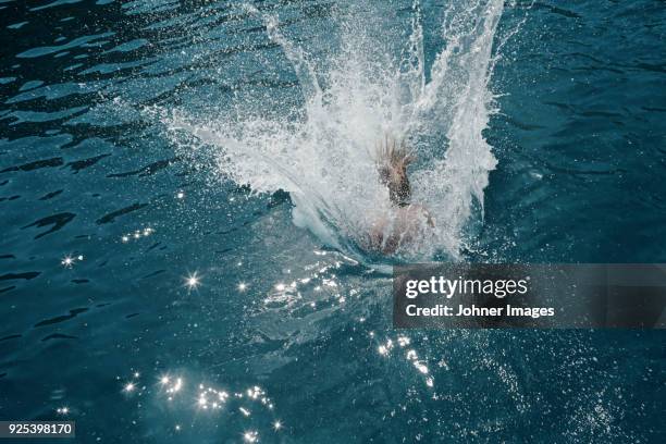 woman jumping into water - sprung ins wasser stock-fotos und bilder