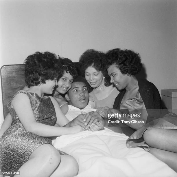 American Heavyweight boxer, Cassius Clay , relaxing in his London hotel room with friends, Brenda Howell, Norma Lindo, Kathleen O"u2019Flaherty and...