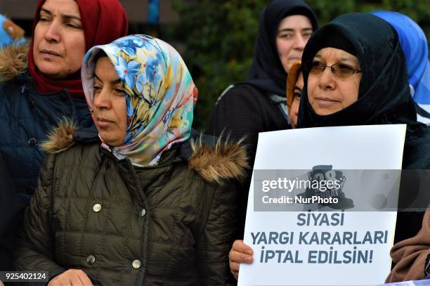 Women look on as an organized group of pro-Islamic demonstrators makes a statement outside the main courthouse on the 21th anniversary of Turkey's...