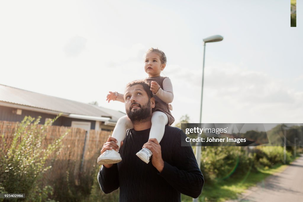 Father carrying daughter on shoulders