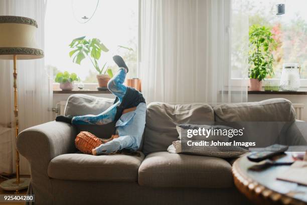girl playing on sofa - somersault stock pictures, royalty-free photos & images