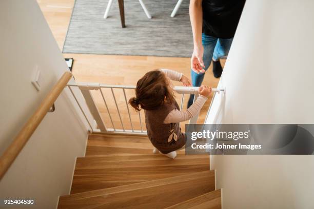 girl opening baby gate in staircase - baby gate stock pictures, royalty-free photos & images